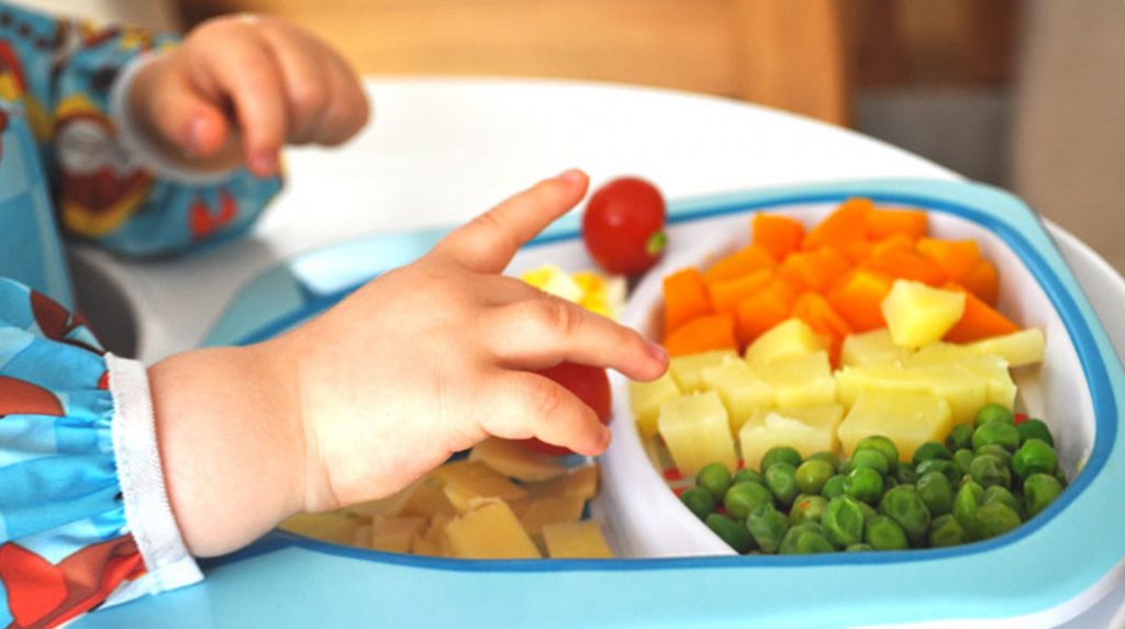 Baby with first finger food