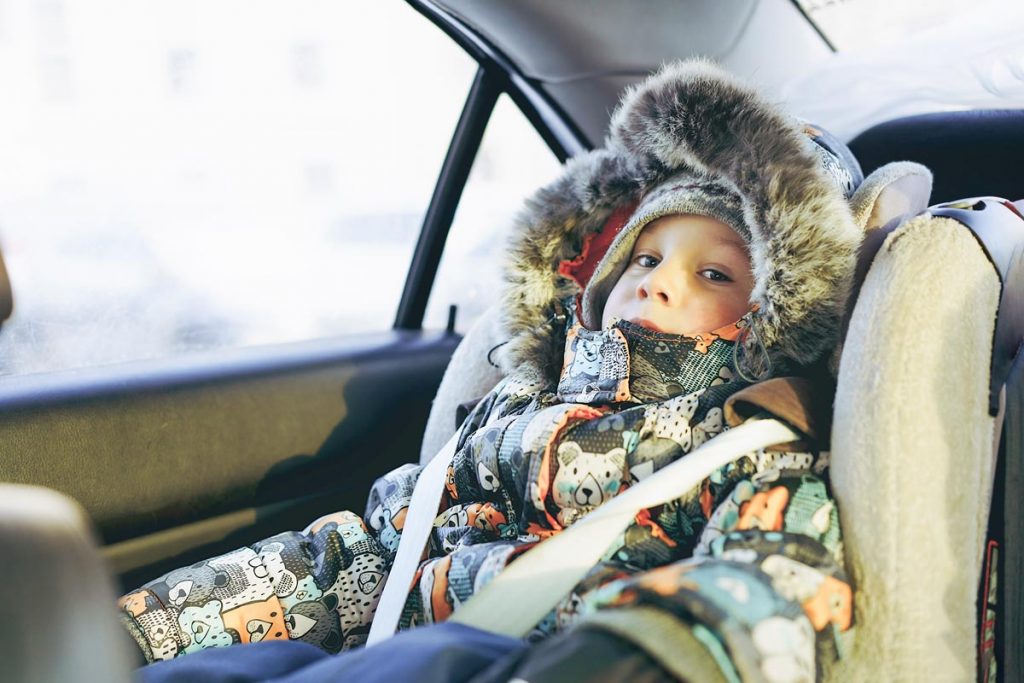 Little boy in car wearing winter jacket