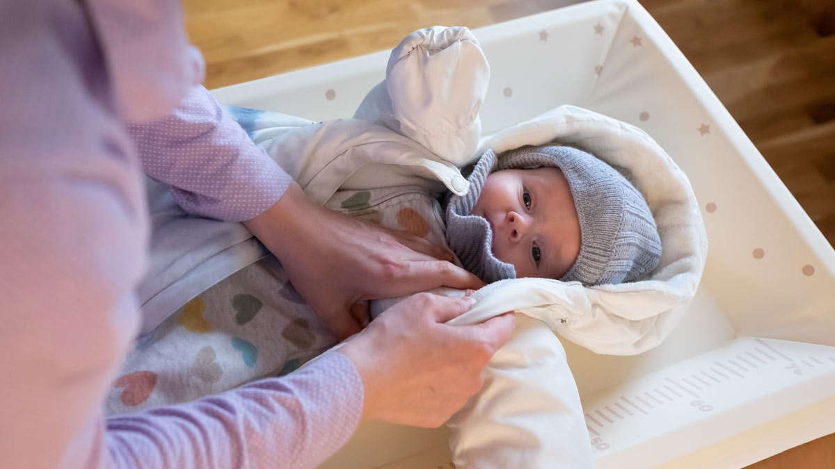 Mother putting warm clothes her baby girl